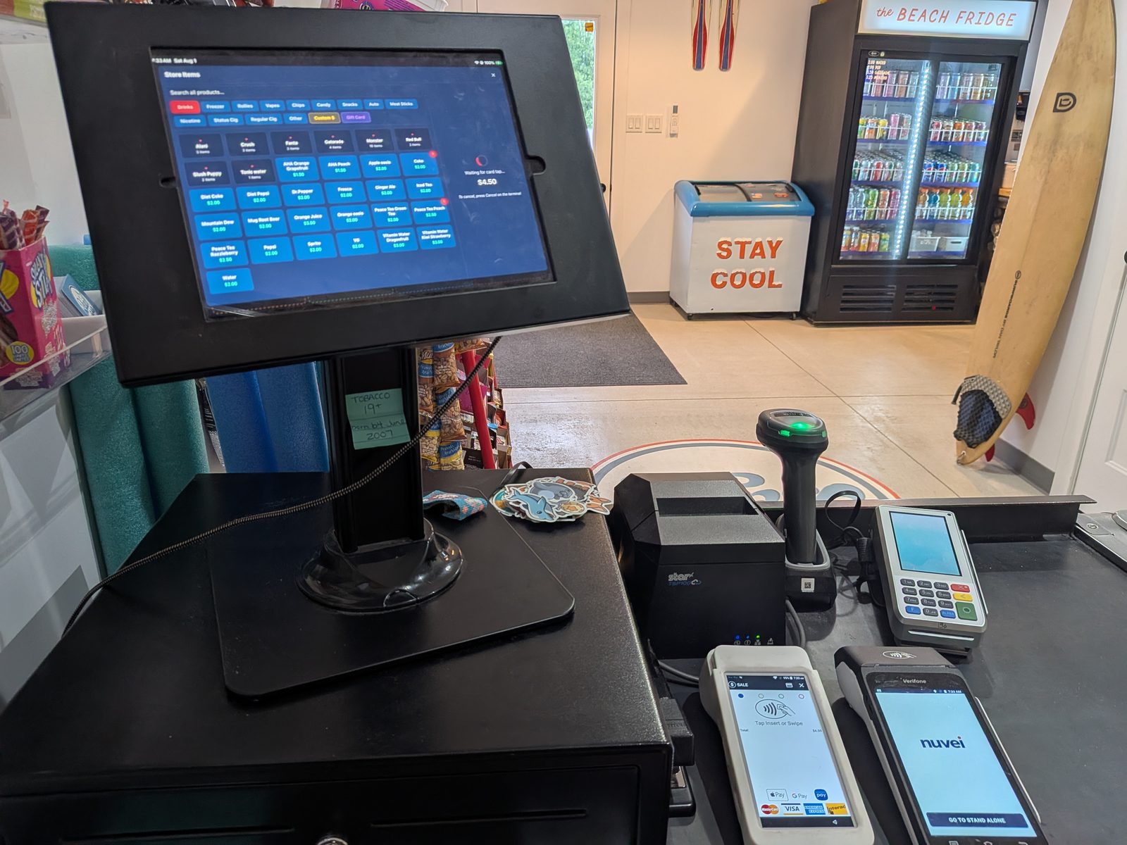 The IslandPoint till at Beach Gas: iPad POS on a stand with receipt printer, barcode scanner, payment terminals and cash drawer, with the store in the background